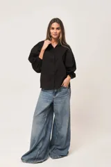 Camisa negra de poplin, corte amplio con mangas abullonadas y botones a tono.