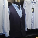 Chaleco azul marino de lana con cuello en V, cierre frontal con botones y bolsillos ribeteados.