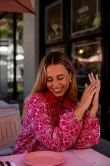 Camisa celeste con estampado de flores blancas, corte clásico, cuello camisero y mangas largas abullonadas.