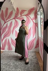 Vestido largo verde oliva con breteles finos y corte evasé. Presenta un panel lateral en color rosa.