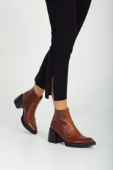 Botas de cuero marrón con textura, de tacón bajo y diseño elegante.