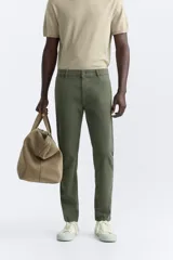 Pantalón chino azul marino, corte skinny fit, confeccionado en tejido de algodón con elasticidad. Cuenta con bolsillos frontales y traseros de vivo. Cierre frontal con cremallera y botón.
