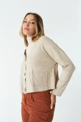 Cardigan tejido color beige con escote en V, cierre con botones, bolsillos delanteros y logo en grifa de cuero.