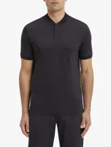 Chomba negra de algodón con cuello mao, manga corta, cartera con dos botones y parche con micro logo en la parte delantera.