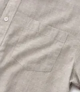 Camisa de hombre de manga corta color arena, confeccionada en lino y algodón. Tiene cuello camisero, corte clásico, cierre frontal con botones, un bolsillo en el pecho y ruedo recto.