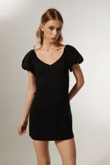 Minivestido negro de viscosa, corte ajustado, escote en V, mangas cortas abullonadas y cierre lateral.