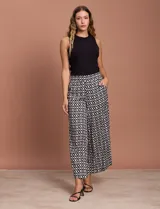 Pantalón capri estampado con flores en tonos celeste, blanco y negro. Tiene pretina elastizada en la parte trasera y bolsillos delanteros.