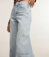 Pantalón wide leg de jeans celeste con cintura alta, bolsillos delanteros, traseros y laterales, cierre con botón y cremallera, y trabillas en la cintura.