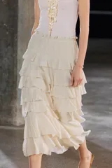 Falda midi color crudo confeccionada en tejido de viscosa, con cintura elástica y volantes en capas.
