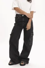 Pantalón de jean negro con efecto lavado, corte ancho, tiro alto y bolsillos cargo laterales.