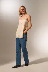 Musculosa negra de bretel fino con encaje en escote y ruedo, de corte holgado y escote profundo.