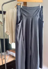 Pantalón palazzo negro de algodón con corte evasé, tiro alto, bolsillos laterales, elástico en la espalda y faja ancha.