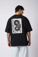 Remera color crema de corte oversize con la palabra "Rewind" bordada en el frente.