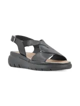 Sandalias de cuero color gris claro con tiras cruzadas y elástico. Suela de plataforma blanca.