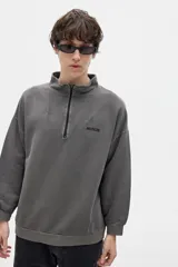 Buzo gris con cuello alto y cierre parcial.