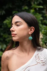 Aros colgantes con forma esférica, hechos con pequeñas cuentas color turquesa.