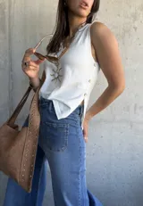 Musculosa blanca tejida con botones dorados en el lateral.