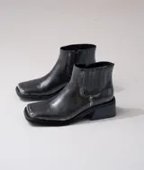 Bota corta negra de cuero con elástico lateral, caña de 12 cm y taco de madera de 4 cm.