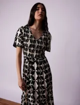 Vestido estampado con escote en V con frunces, cintura elastizada con lazo de ajuste y mangas cortas con detalles en broderie.