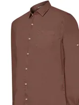 Camisa de hombre manga larga color marrón, confeccionada en popelina de algodón orgánico. Tiene cuello italiano, calce regular, bolsillo en el pecho con logo bordado y mangas ajustables con botón.