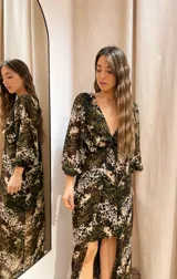 Vestido largo con estampado animal print en tonos verde y marrón, escote en V, mangas largas abullonadas y falda con capas.