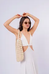 Vestido largo blanco con escote en V, abertura en la cintura y breteles finos.