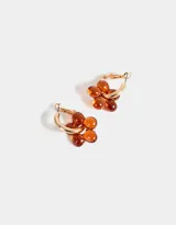 Aros tipo argolla dorados con dije de flor color naranja.