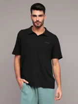 Chomba negra de algodón con textura de crepé, corte regular, manga corta y cuello abierto. Logo de Calvin Klein bordado en el pecho.