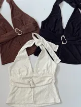 Top halter con escote en V y detalle de hebilla metálica en el centro.
