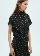 Blusa negra con estampado de lunares color beige, de manga corta y cuello alto con detalle drapeado.