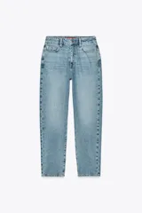 Pantalón de jean celeste de corte mom fit, tiro alto, largo tobillero y cinco bolsillos.