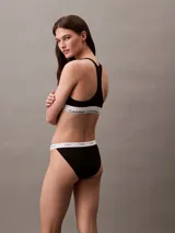 Conjunto Calvin Klein negro, compuesto por un corpiño deportivo con elástico con logo y una tanga con elástico con logo.