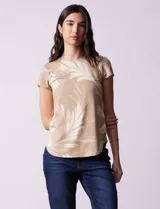 Remera de modal color beige con estampado de hojas blancas, cuello redondo y mangas cortas.