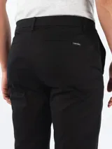 Pantalón de vestir negro, corte slim, con cierre de botón y cremallera.