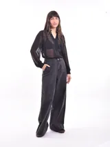 Camisa negra traslúcida con lunares, cuello en V con volados y botones frontales.