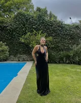 Vestido largo negro con escote en V, cut outs laterales bajo el busto y breteles finos cruzados y atados en la espalda.