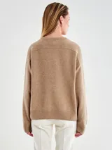 Sweater negro de calce relajado con cuello redondo y mangas largas, con terminaciones acanaladas en puños y ruedo.