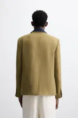 Blazer color marrón claro, de corte recto y doble botonadura. Confeccionado en tejido de lyocell y lino.