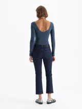 Jeans de mezclilla azul oscuro, tiro medio, con corte cropped y levemente acampanado en la botamanga.