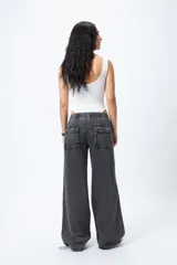 Pantalón jean ancho color gris oscuro, con elástico en la cintura y cordones ajustables en los bajos. Cuenta con grandes bolsillos laterales y traseros.