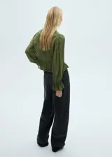 Blusa verde oliva de gasa con cuello de pico, volantes y mangas largas abullonadas.
