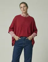 Poncho tejido de punto grueso, color mostaza/mostaza oscuro, con cuello redondo y caída amplia.