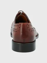 Zapato de vestir acordonado color marrón, con puntera brogue y detalles de perforaciones.