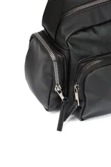 Bandolera color crudo con correa ajustable, bolsillo frontal con cierre y bolsillos laterales con cierre.