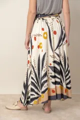 Pollera larga de viscosa color crudo con estampado de hojas azules y detalles en marrón y rojo.
