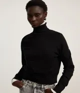 Blusa de punto color blanco, con cuello alto, manga larga y diseño liso.