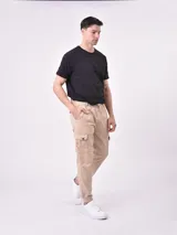 Pantalón jogger gris oscuro con cintura elástica ajustable con cordón, bolsillos laterales y bolsillo cargo con solapa en la pierna. Puños elásticos en los tobillos.