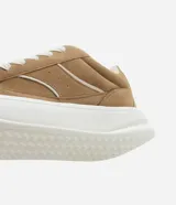 Championes de skate color marrón, confeccionados en material sintético con cordones anchos blancos, suela alta blanca y detalles contrastantes en los laterales.