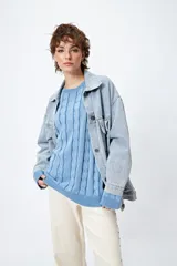 Sweater color beige con diseño de ochos en relieve, cuello redondo y corte oversize.