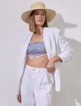 Blazer blanco de lino con cuello con solapa, bolsillos sastre y mangas fruncidas.